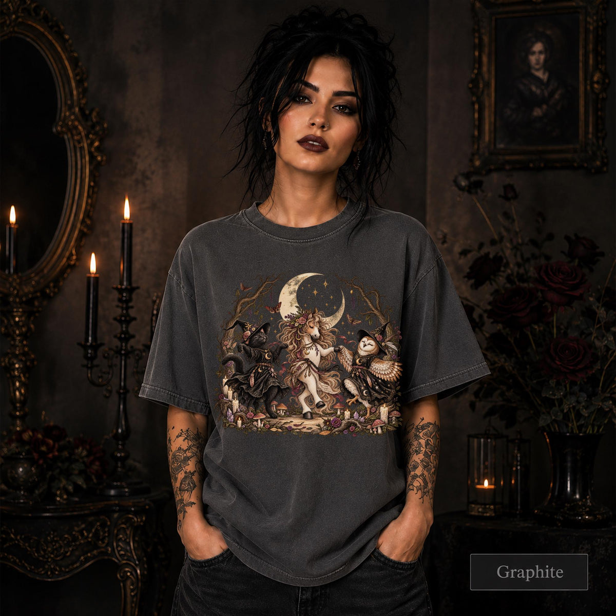 Graphite unisex T-shirt featuring a gothic fantasy scene with a unicorn, owls, raven, crescent moon, mushrooms, candles, flowers, and twisted woodland branches.