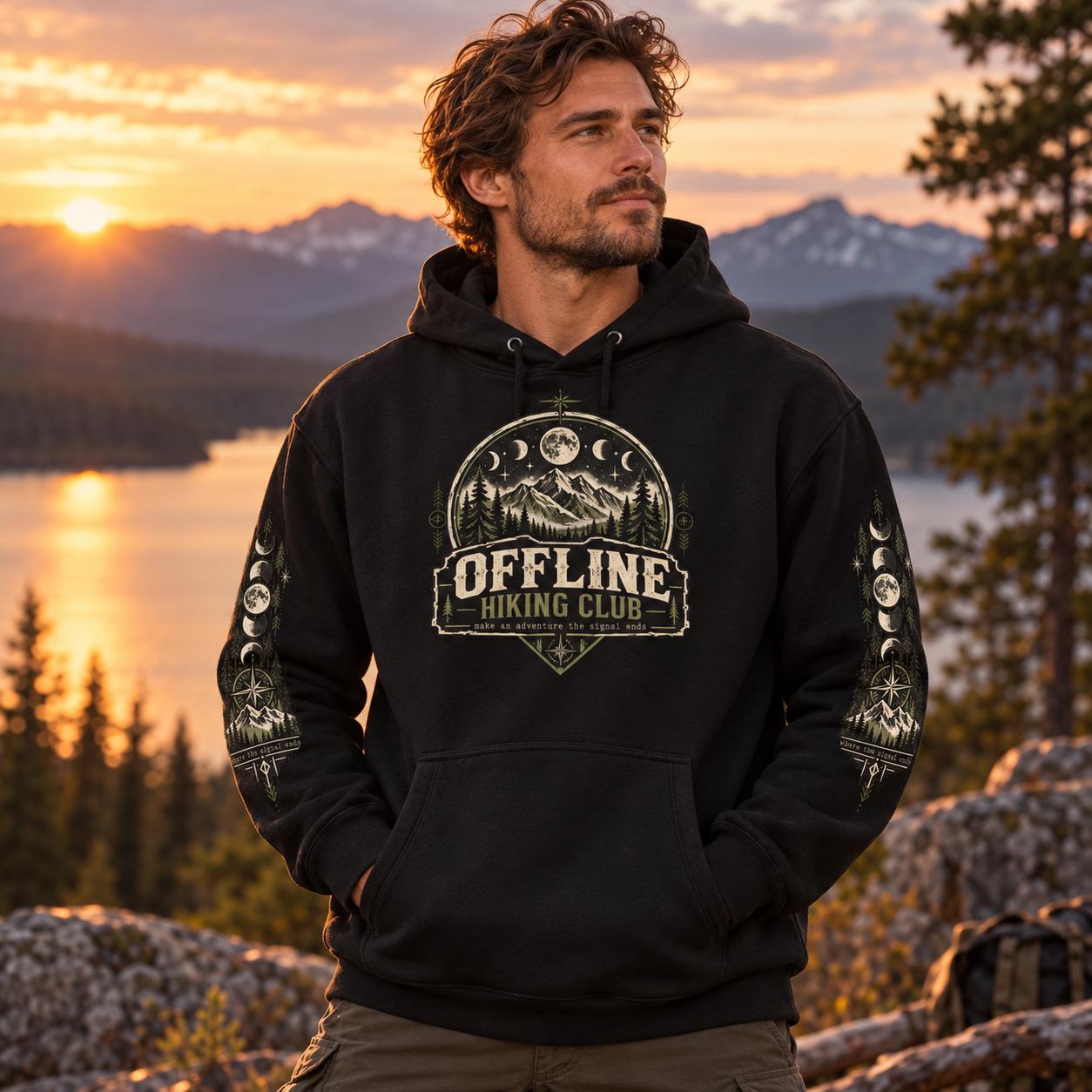Outdoor lifestyle mockup of the Offline Hiking Club heavyweight hoodie featuring the mountain, pine tree, moon phase, and compass design in a rugged nature setting.