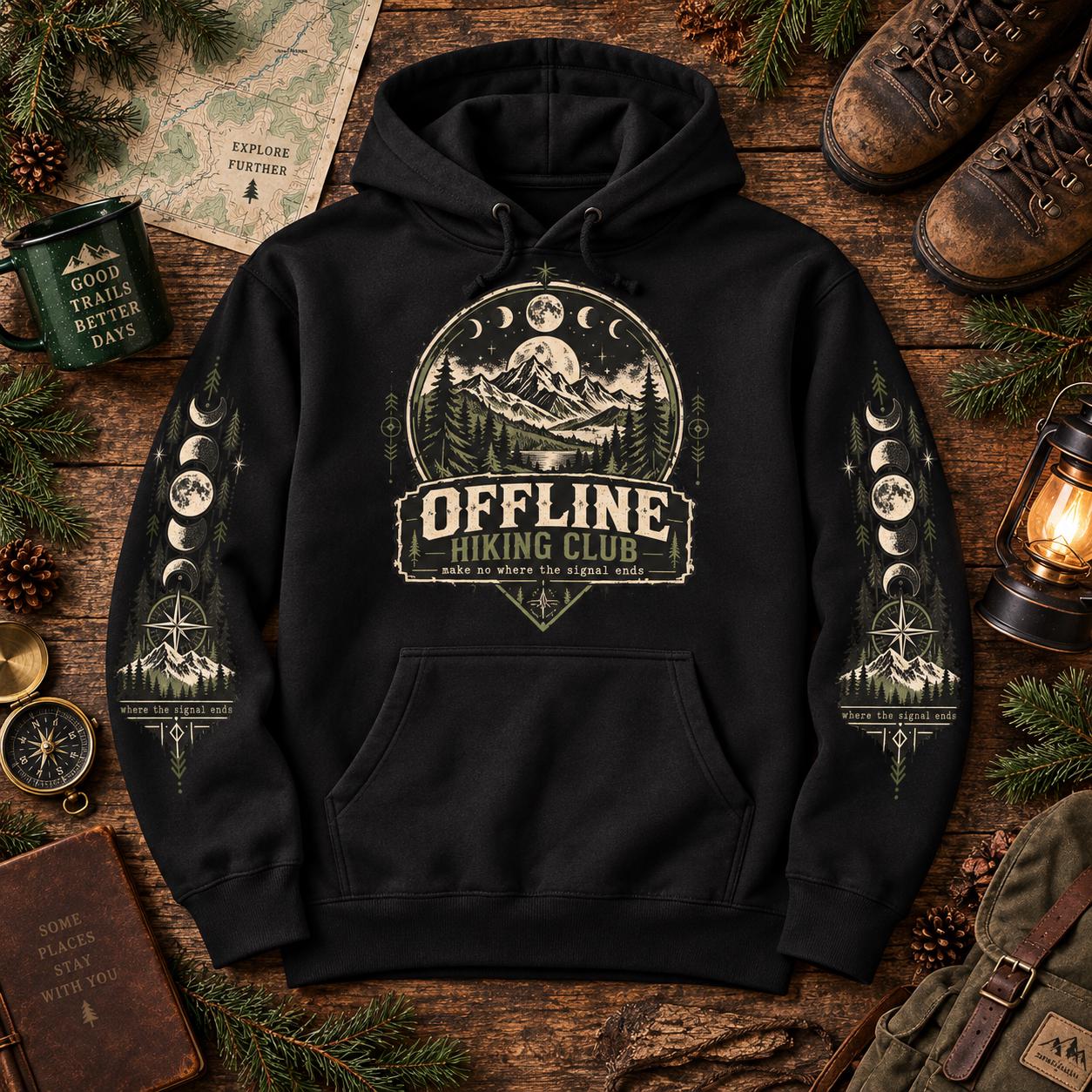 Black Offline Hiking Club hoodie shown in an outdoor adventure flat lay with the front graphic and matching moon phase sleeve designs.