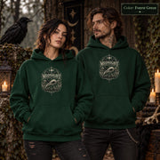 Forest Green unisex hoodie shown from the front with a smaller Midnight Naturalist Society bird skull emblem centered on the chest in a dark academia inspired style.