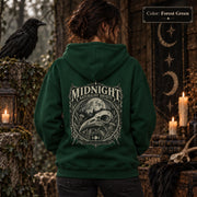 Forest Green unisex hoodie shown from the back with a large Midnight Naturalist Society graphic featuring a bird skull, moon, mountains, forest plants, and vintage gothic botanical details.