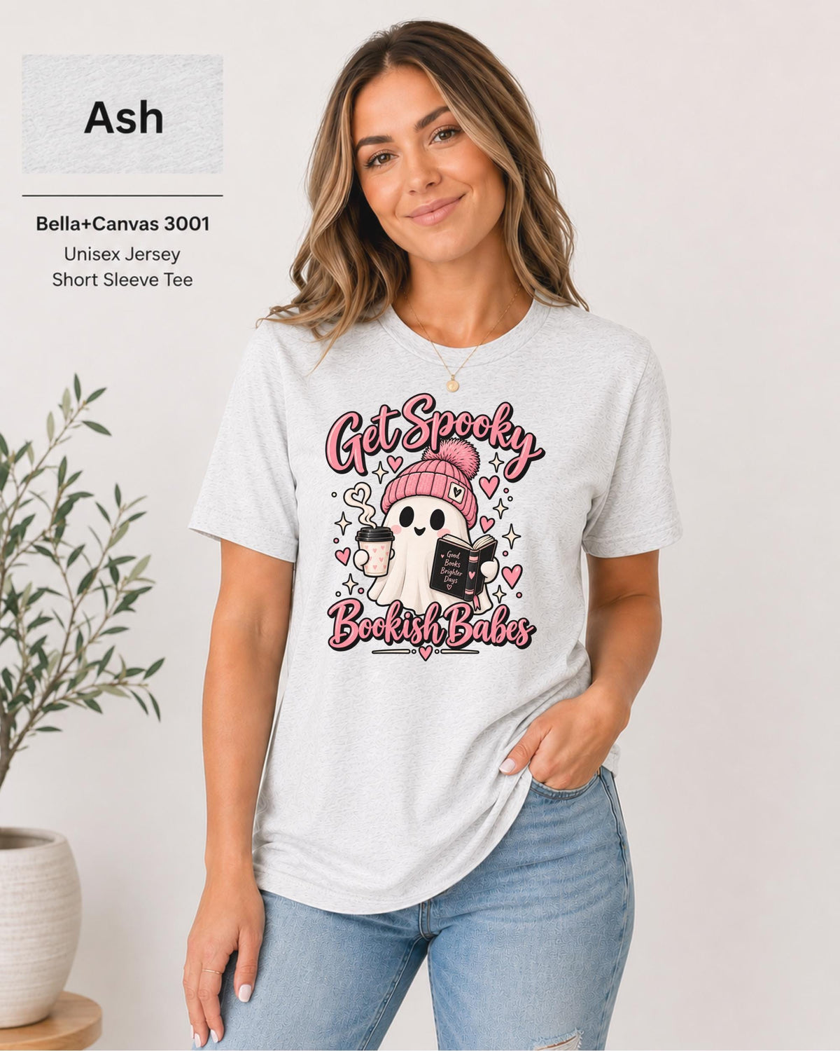 Bella+Canvas 3001 Ash unisex T-shirt featuring a cute ghost in a pink beanie holding coffee and a book with “Get Spooky Bookish Babes” lettering, hearts, and stars.