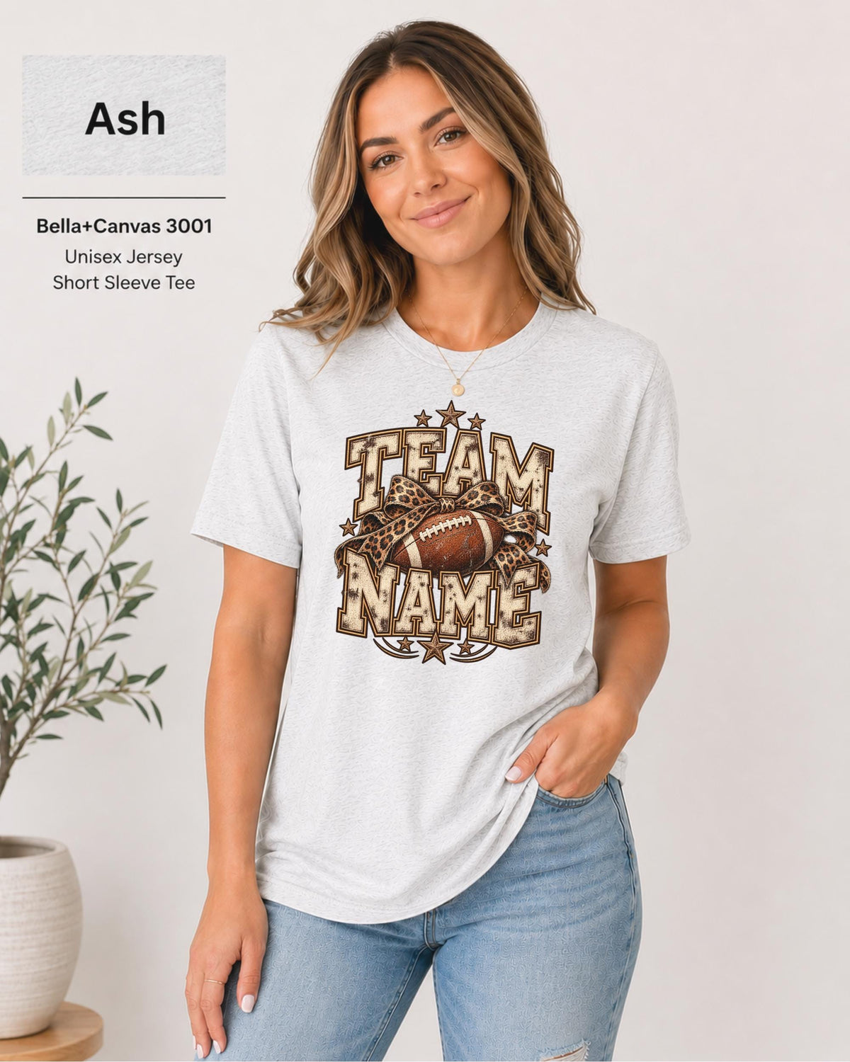 Ash Bella+Canvas 3001 unisex T-shirt featuring a customizable vintage football graphic with bold “Team Name” lettering, leopard-print bow, stars, and distressed varsity details.