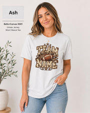 Ash Bella+Canvas 3001 unisex T-shirt featuring a customizable vintage football graphic with bold “Team Name” lettering, leopard-print bow, stars, and distressed varsity details.