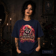 Female model wearing a true navy Comfort Colors 1717 tee featuring a colorful raccoon beneath a glowing moon with mushrooms and the phrase “I Put the Fun in Dysfunctional.”