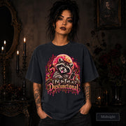 Female model wearing a midnight Comfort Colors 1717 tee featuring a colorful raccoon beneath a glowing moon with mushrooms and the phrase “I Put the Fun in Dysfunctional.”