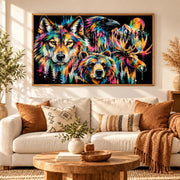 Colorful wilderness wall print displayed over a cozy couch, featuring layered forest animals, mountains, and bright abstract brushwork.