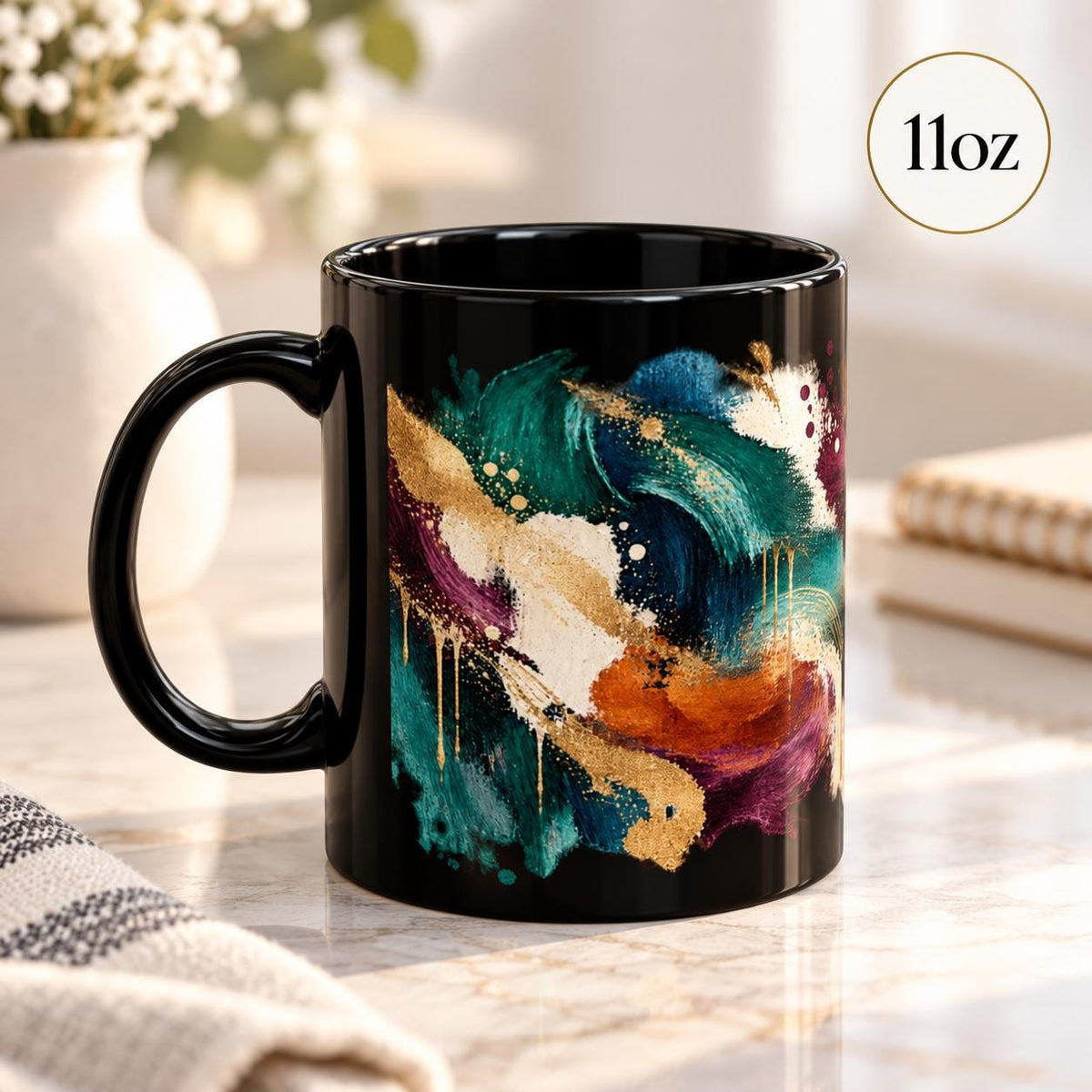11 oz coffee cup angled to display layered painterly strokes, splashes, and metallic-inspired gold details against the dark background.
