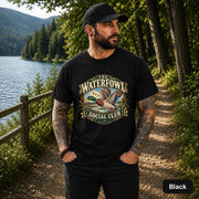 Black unisex T-shirt featuring the “Waterfowl Social Club” mallard duck graphic with marsh grass, lake scenery, and vintage outdoor styling.