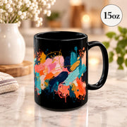 15 oz black coffee cup angled to showcase the full painterly pattern with bright brushstrokes and splattered accents.