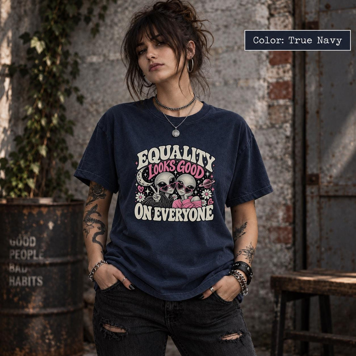 True Navy tee displaying the inclusive alien graphic with retro lettering, pink details, and a playful space-inspired layout.