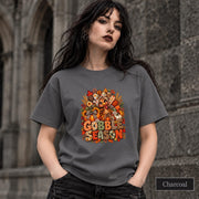 Charcoal unisex tee displaying the festive turkey graphic with warm orange, rust, cream, and harvest-inspired details.