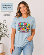Heather Prism Dusty Blue Bella+Canvas 3001 T-shirt featuring the colorful “Kindness Over Cruelty” anti-bullying design with smiley faces, hearts, stars, and checkerboard accents.