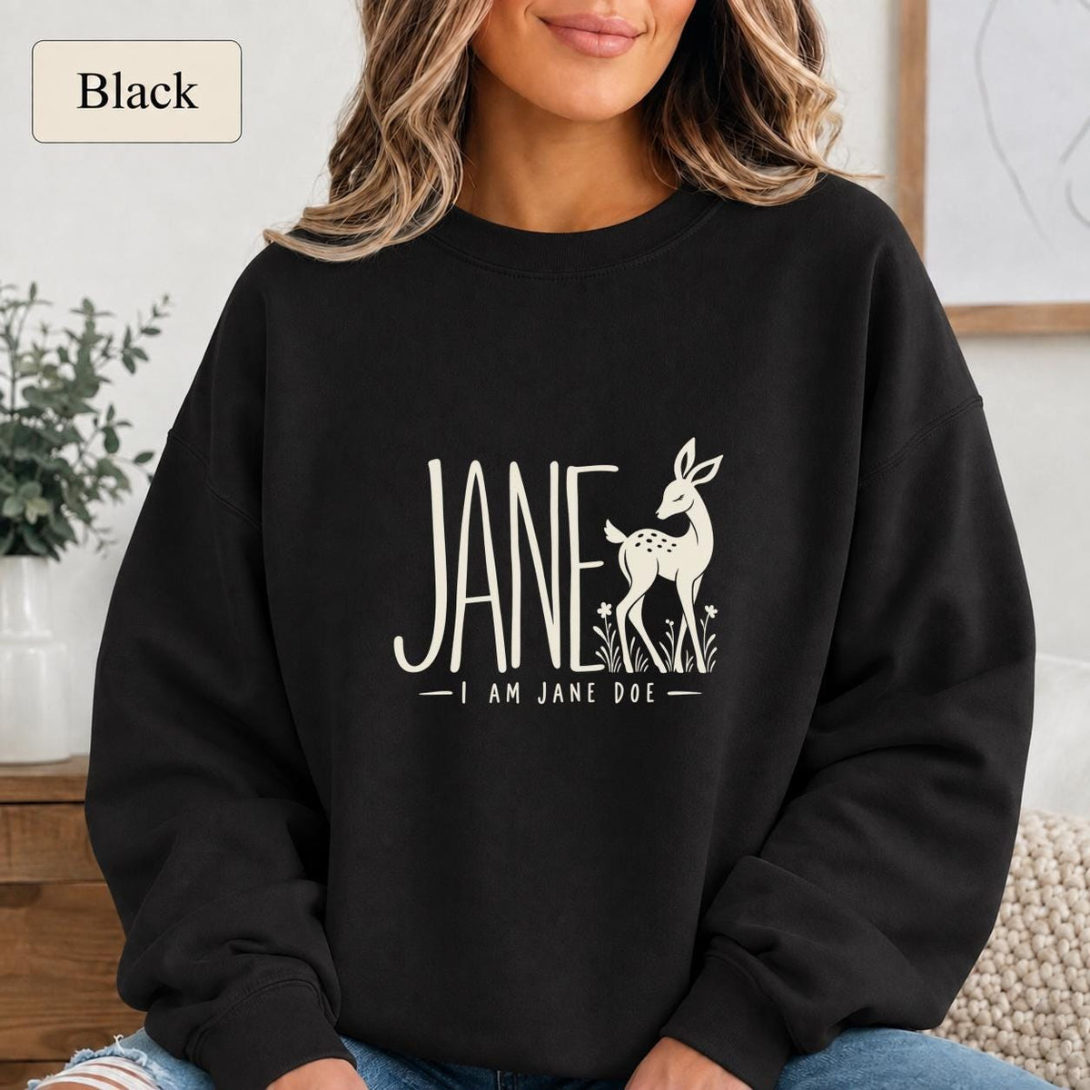 Black Gildan 18000 crewneck sweatshirt featuring large cream “Jane” lettering, a minimalist doe illustration, and the phrase “I Am Jane Doe.”