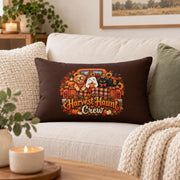 Brown Harvest Haunt Crew lumbar pillow with autumn truck, dog, ghost, black cat, crow, pumpkins, sunflowers, and fall leaves styled on a cozy cream sofa.