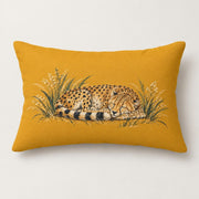 Mustard yellow rectangular lumbar pillow shown on a light neutral background with a sleeping spotted cheetah curled in painted grasses