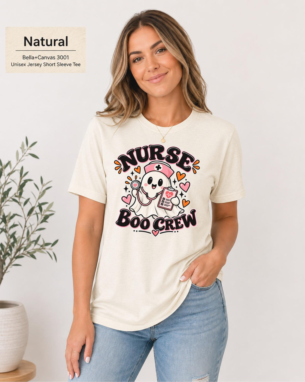 Nurse Boo Crew T-shirt in Natural featuring a cute ghost nurse with a pink cap, stethoscope, clipboard, hearts, and playful Halloween accents.