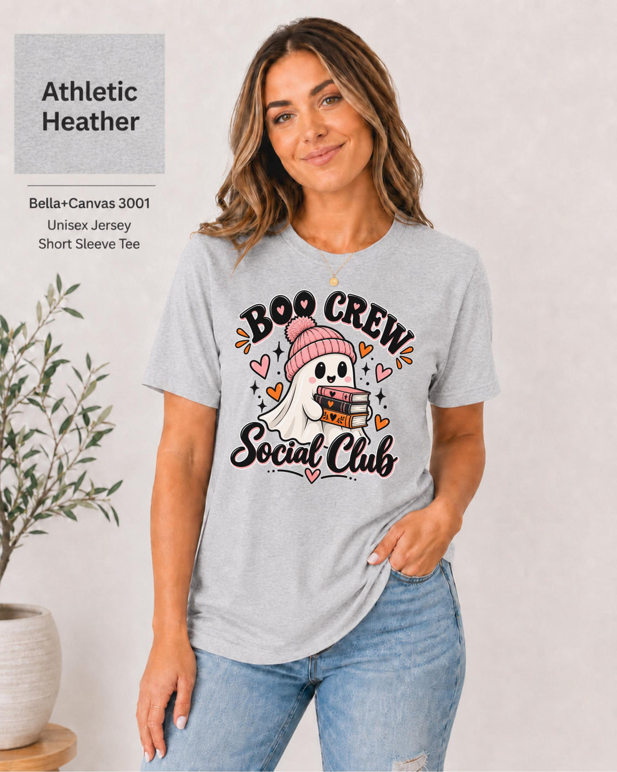 Boo Crew Social Club T-shirt in Athletic Heather featuring a cute ghost in a pink beanie holding books, with hearts, sparkles, and playful Halloween lettering.