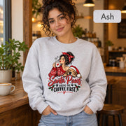 Female model wearing an ash grey crewneck sweatshirt with the festive “Santa Paws Bring Me Coffee First” dog lover Christmas graphic.