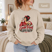 Female model wearing a sand-colored crewneck sweatshirt featuring the “Santa Paws Bring Me Coffee First” holiday coffee and dog design.