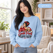 Female model wearing a light blue crewneck sweatshirt with the “Santa Paws Bring Me Coffee First” Christmas dog and coffee graphic.