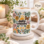 Daily Reminders ceramic mugs in 15 oz featuring colorful floral, sunshine, heart, and moon artwork with positive self-care phrases including drink water, be kind to yourself, you are enough, one step at a time, and progress over perfection.