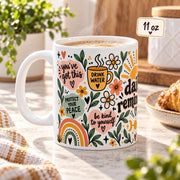 Daily Reminders ceramic mugs in 11 oz featuring colorful floral, sunshine, heart, and moon artwork with positive self-care phrases including drink water, be kind to yourself, you are enough, one step at a time, and progress over perfection.