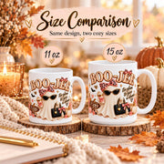 Size comparison mockup showing the Boo-Jee ghost mug design in both 11 oz and 15 oz sizes side by side in a warm rustic autumn setting with soft seasonal decor.