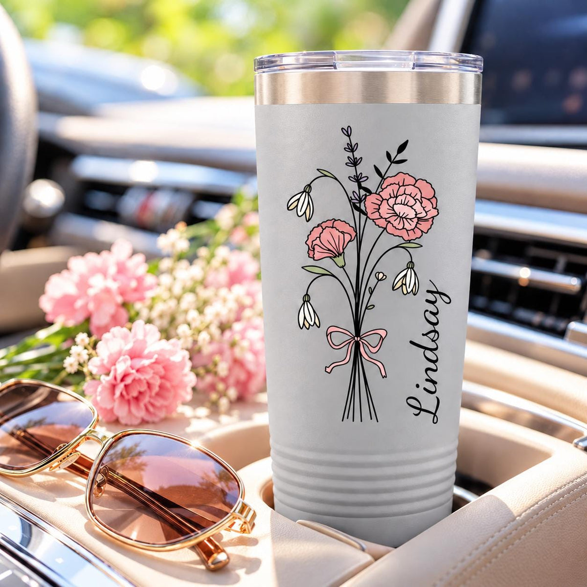 White 20oz personalized floral tumbler featuring a delicate pink bouquet, ribbon detail, and custom vertical name in a car cup holder.