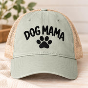 Sage green women’s mesh-back hat featuring the embroidered Dog Mama text and paw print design.
