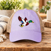 Lavender women’s washed mesh-back cap featuring an embroidered flying mallard duck with red, green, white, and blue thread details.