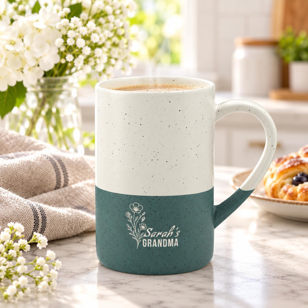 Forest Green and cream 13oz ceramic mug featuring a delicate engraved floral design with personalized “Grandma” wording, styled beside books and neutral home decor.
