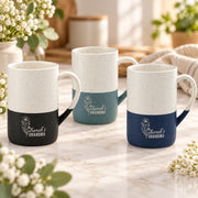 Three personalized 13oz ceramic mugs shown together in black, muted teal, and navy color options with engraved floral Grandma designs.