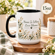 15oz ceramic mug featuring the “Home Is Where Love Blooms” floral artwork with black handle and interior.