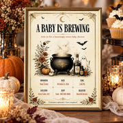 Vintage A Baby Is Brewing Halloween baby shower invitation with gothic pumpkins, celestial accents and editable Canva event details.