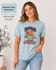 Woman wearing an Heather Prism Dusty Blue Bella+Canvas 3001 unisex t-shirt featuring a cute pumpkin nurse graphic and the phrase “Nurse Cute But Clinically Tired.”