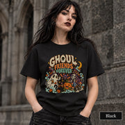 Black unisex T-shirt featuring a colorful “Ghoul Friends Forever” Halloween graphic with a ghost, black cat, pumpkin, witchy skeleton, bats, mushrooms, crescent moon, and autumn accents.