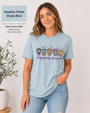 Bella+Canvas 3001 Heather Prism Dusty Blue unisex T-shirt featuring five cute Halloween-inspired characters with stars and the phrase “Stay Spooky, Be Sweet” in a small centered chest design.