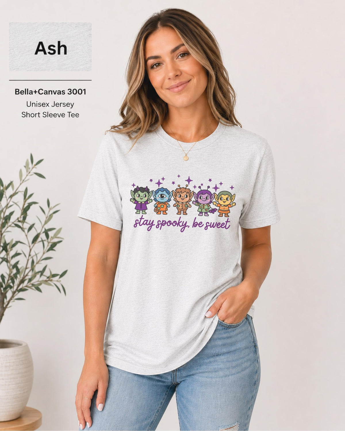 Bella+Canvas 3001 Ash unisex T-shirt featuring five cute Halloween-inspired characters with stars and the phrase “Stay Spooky, Be Sweet” in a small centered chest design.