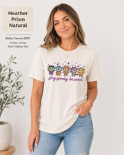 Bella+Canvas 3001 Heather Prism Natural unisex T-shirt featuring five cute Halloween-inspired characters with stars and the phrase “Stay Spooky, Be Sweet” in a small centered chest design.