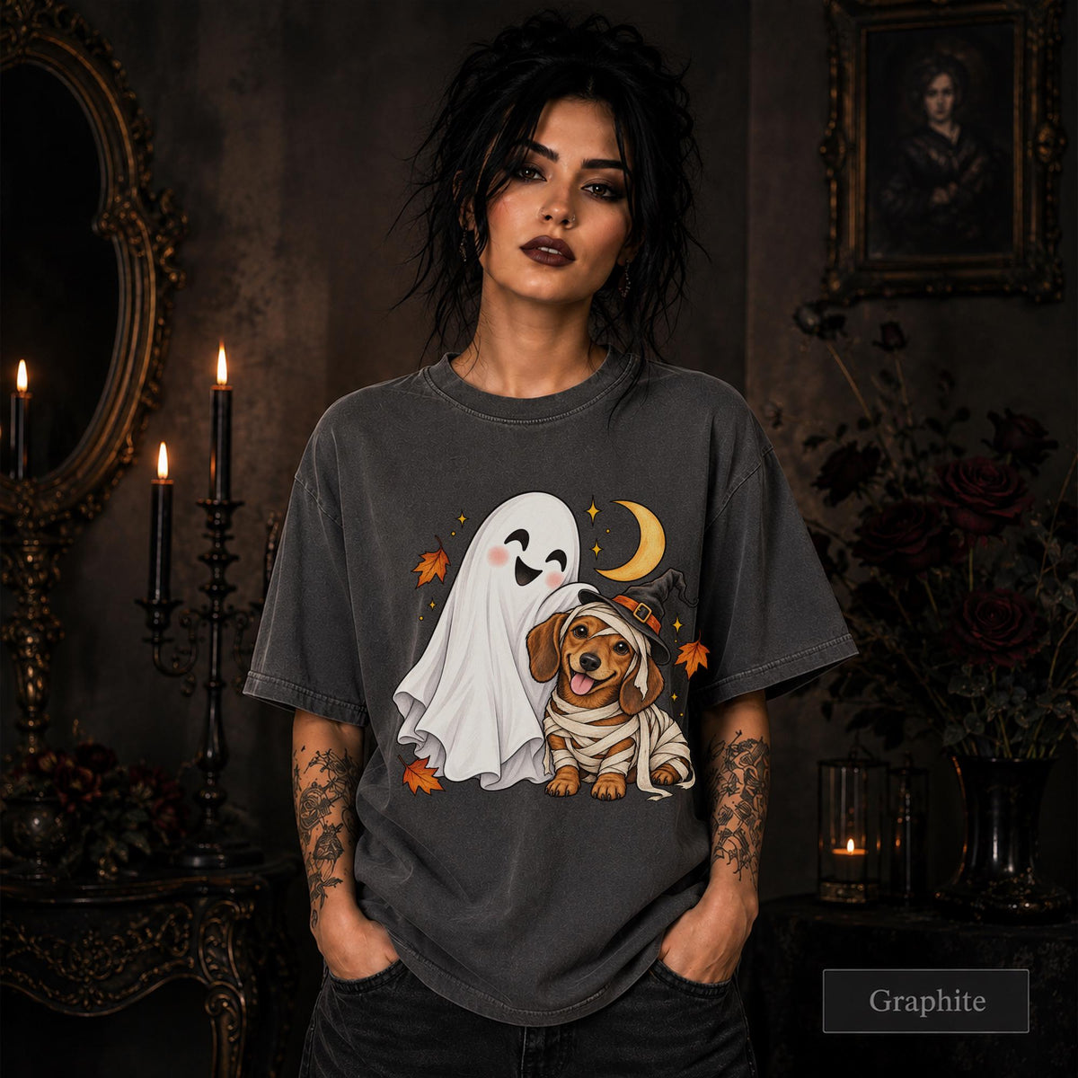 Graphite unisex T-shirt featuring a smiling white ghost beside a mummy-wrapped puppy wearing a witch hat, with a crescent moon, stars, and orange autumn leaves.