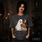 Graphite unisex T-shirt featuring a smiling white ghost beside a mummy-wrapped puppy wearing a witch hat, with a crescent moon, stars, and orange autumn leaves.