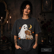 Pepper unisex T-shirt featuring a smiling white ghost beside a mummy-wrapped puppy wearing a witch hat, with a crescent moon, stars, and orange autumn leaves.