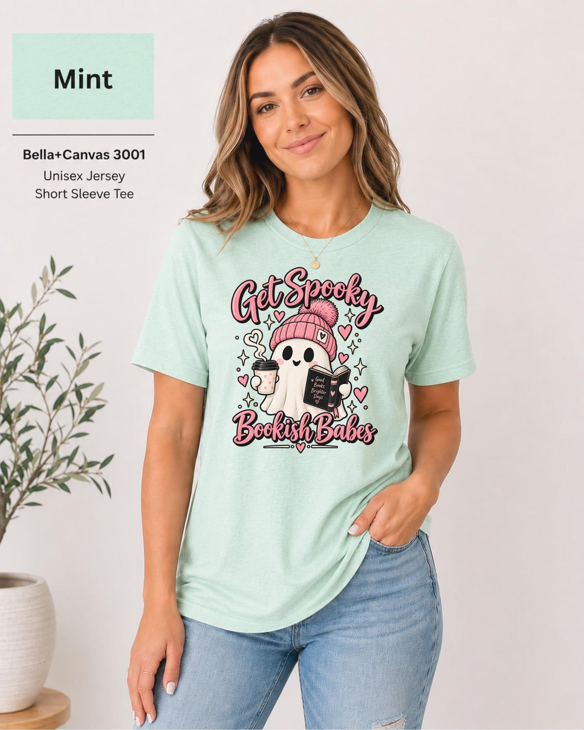 Bella+Canvas 3001 Mint unisex T-shirt featuring a cute ghost in a pink beanie holding coffee and a book with “Get Spooky Bookish Babes” lettering, hearts, and stars.