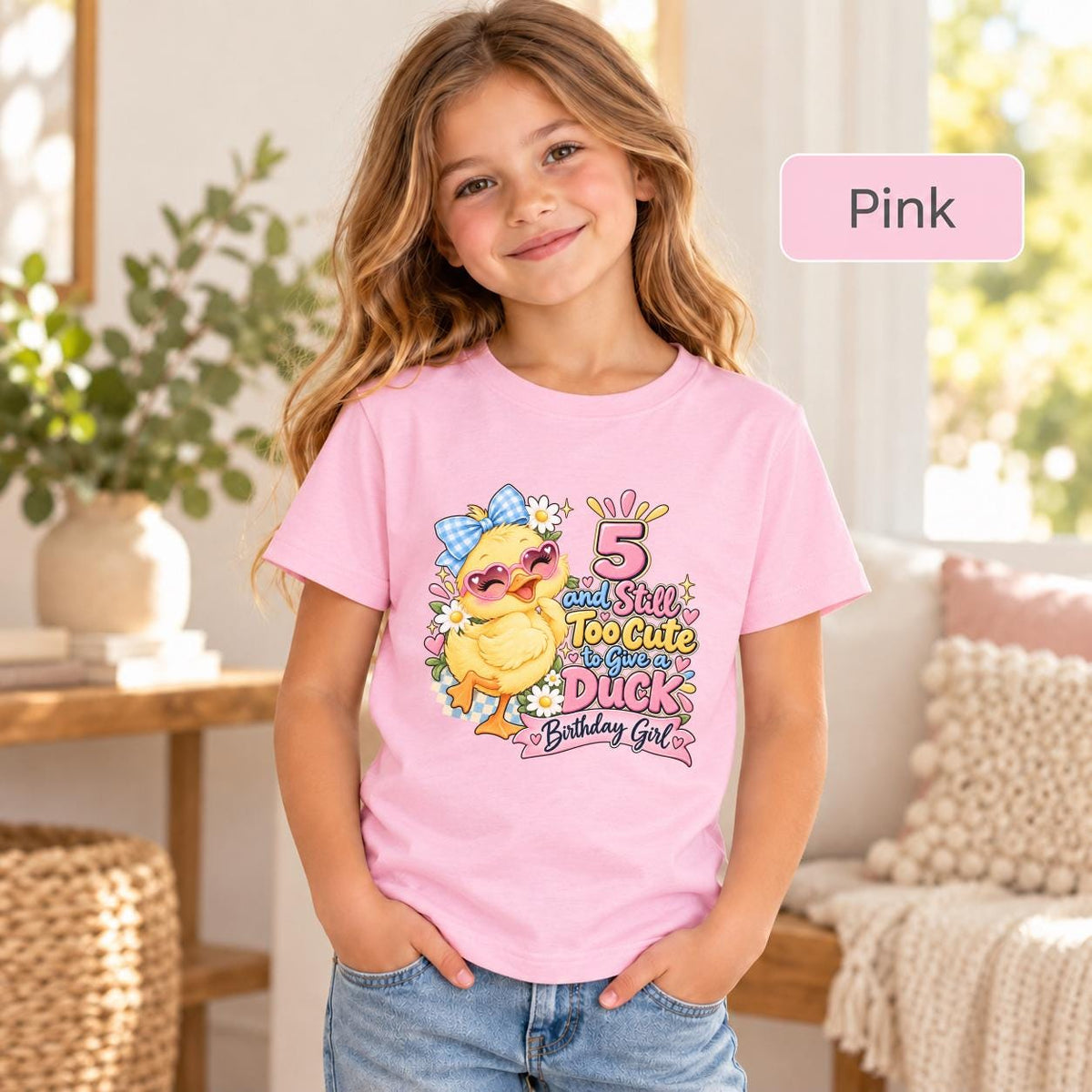 Pink youth tee displaying the cheerful duck birthday graphic with a yellow duckling, pastel party details, and bright celebration lettering.