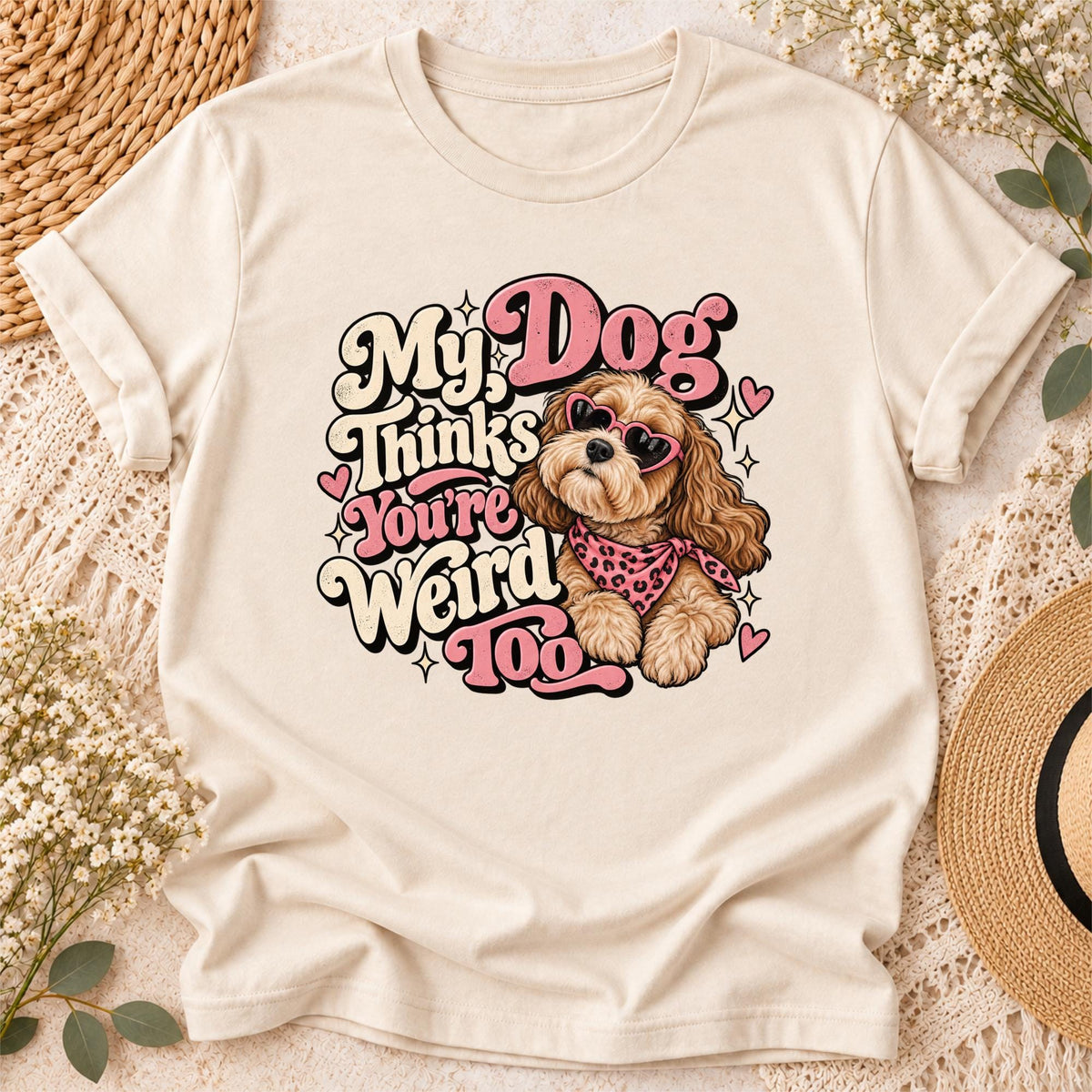 Funny My Dog Thinks You're Weird Too digital PNG design displayed on a cream T-shirt, featuring a fluffy brown dog wearing pink heart sunglasses and a leopard-print bandana.