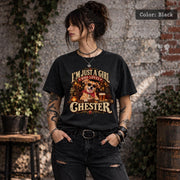 Woman wearing a black custom dog photo T-shirt showing Chester in sunglasses with a personalized name, warm amber lighting and vintage-inspired graphics.