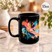 15 oz black coffee cup angled to showcase the full painterly pattern with bright brushstrokes and splattered accents.