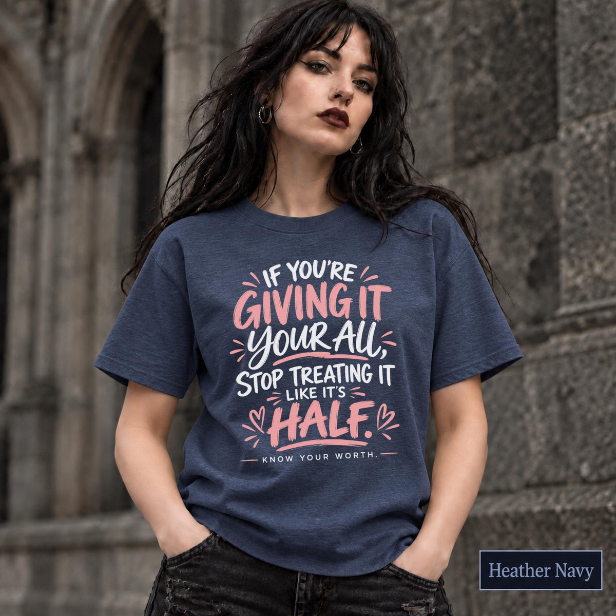 Navy tee featuring the empowering quote design in pink and white text with a clean statement layout.