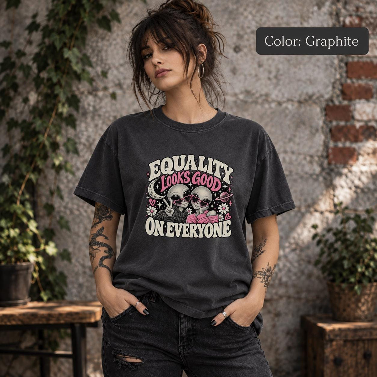Graphite Comfort Colors 1717 T-shirt featuring the phrase “Equality Looks Good on Everyone” with two aliens in heart-shaped sunglasses, stars, flowers, hearts, and cosmic accents.